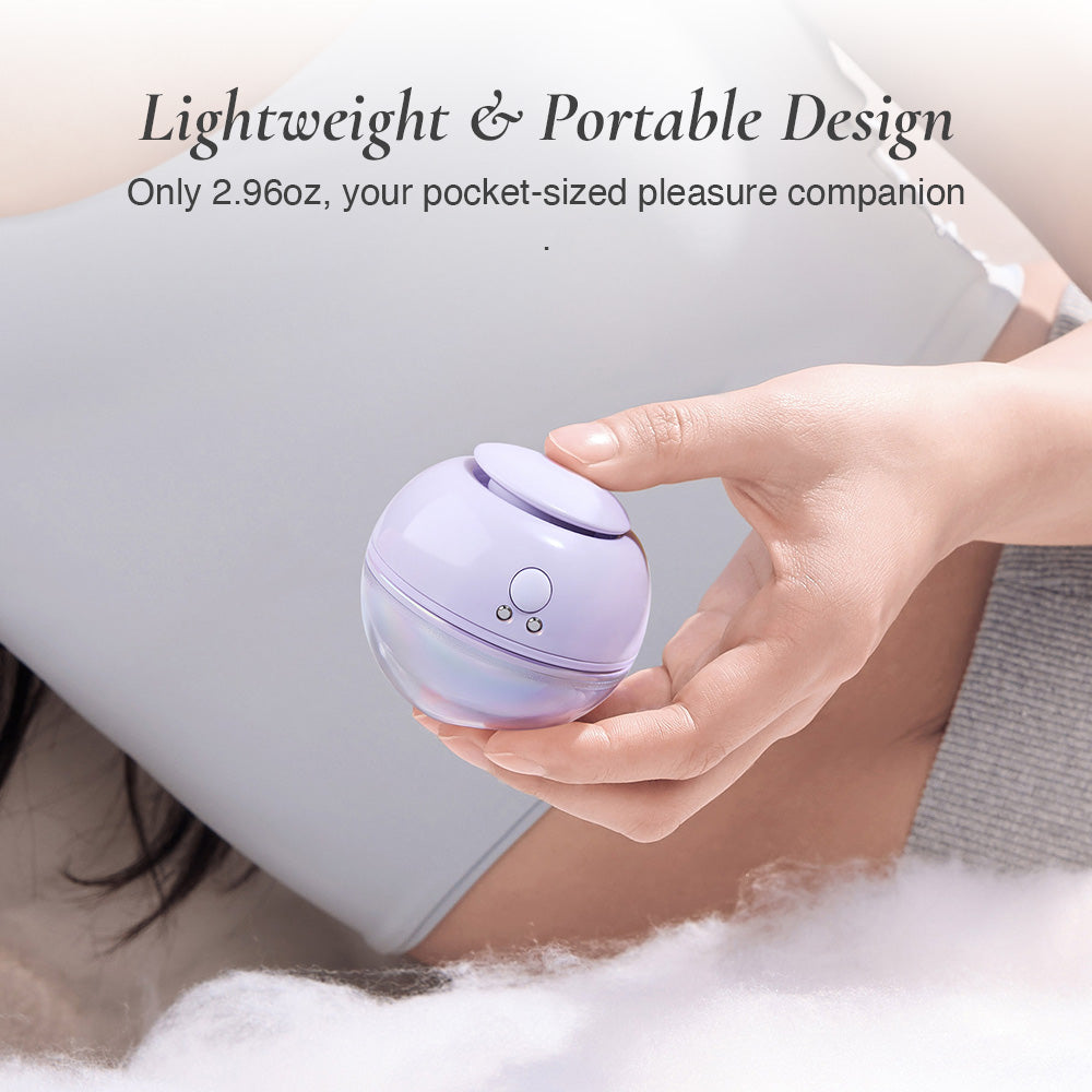 Hand holding a small purple bubble clitoral stimulator device with lightweight and portable design.