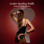 Woman holding a leather spanking paddle for bdsm beginners