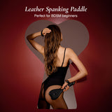 Woman holding a leather spanking paddle for bdsm beginners