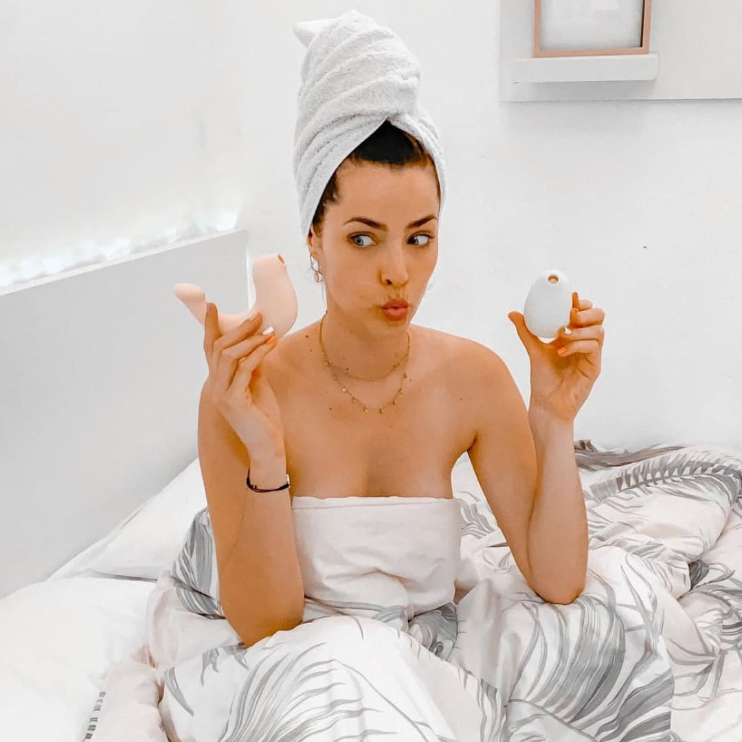 Woman applying makeup in bed with a towel on her head
